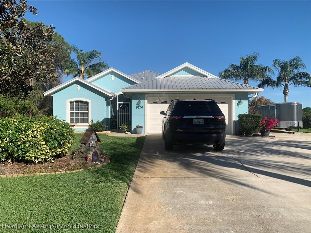 single story home with a garage and a front yard