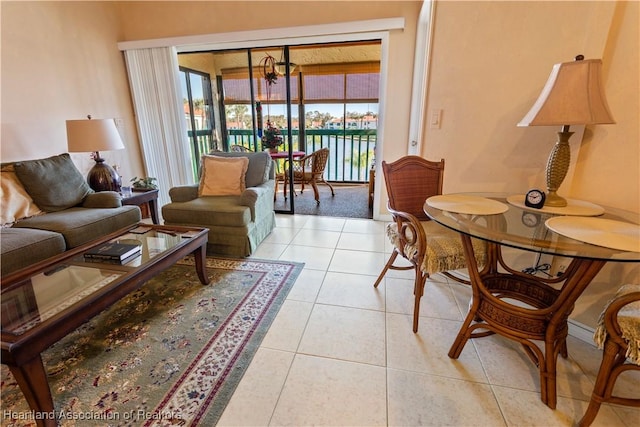 sitting room with a water view, a wealth of natural light, and light tile patterned flooring