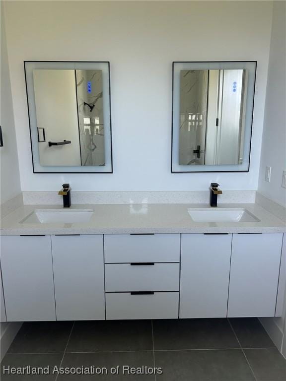 bathroom with tile patterned flooring, vanity, and a shower