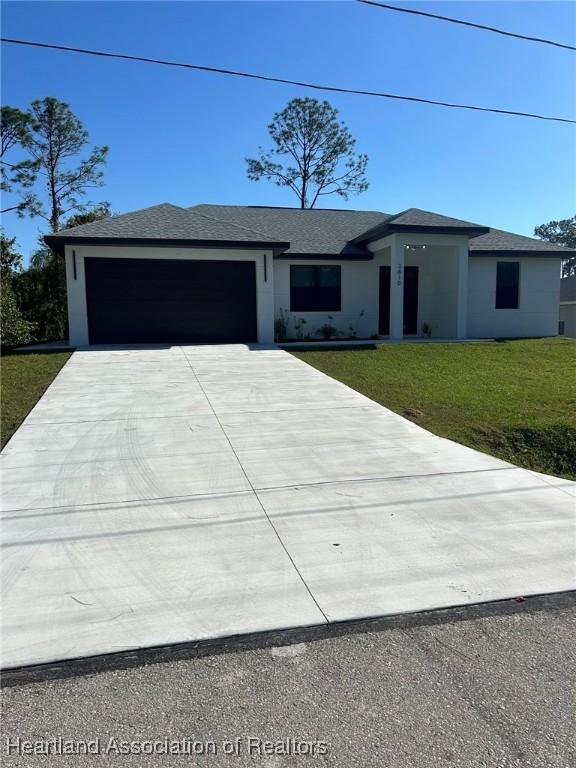 view of front of house featuring a garage and a front lawn