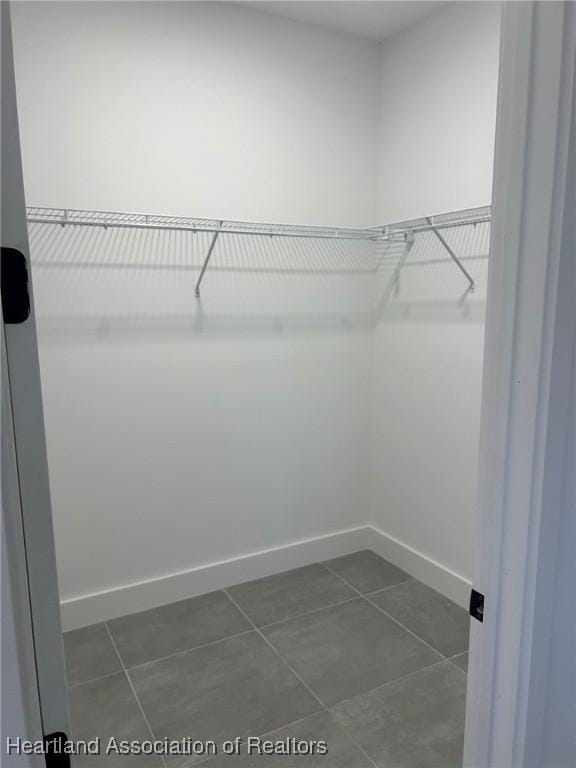 spacious closet featuring dark tile patterned floors