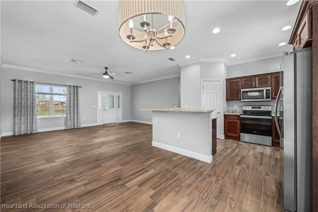 kitchen featuring dark hardwood / wood-style flooring, light stone counters, ceiling fan with notable chandelier, and appliances with stainless steel finishes