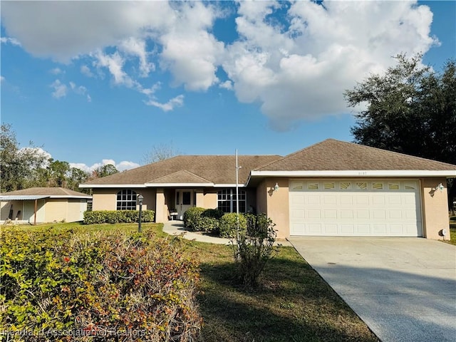 single story home featuring a garage, concrete driveway, and stucco siding