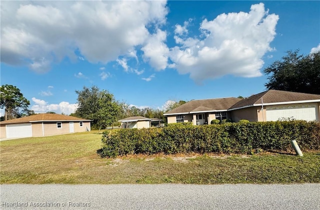 ranch-style home with a garage and a front lawn