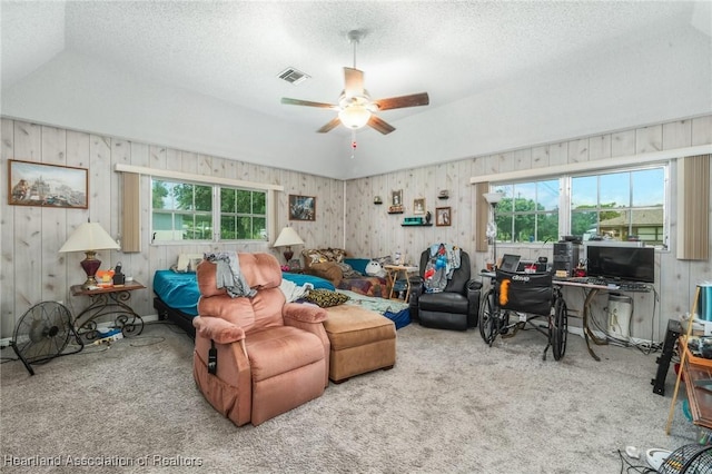 living room featuring carpet flooring, ceiling fan, and a textured ceiling