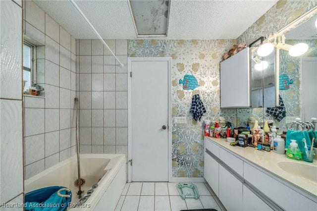 bathroom featuring tile patterned floors, vanity, a textured ceiling, and tiled shower / bath