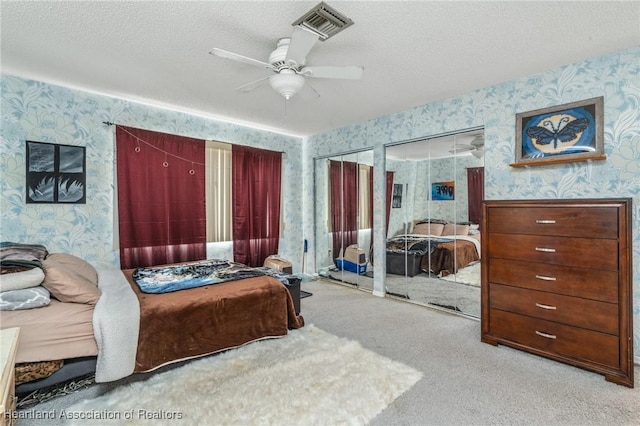 bedroom featuring carpet, a textured ceiling, a closet, and ceiling fan