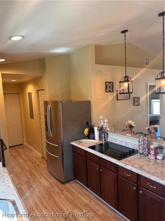 2633 W Newton Rd, Avon Park, FL 33825 - kitchen with light wood-style flooring, pendant lighting, black electric cooktop, visible vents, and stainless steel refrigerator with ice dispenser