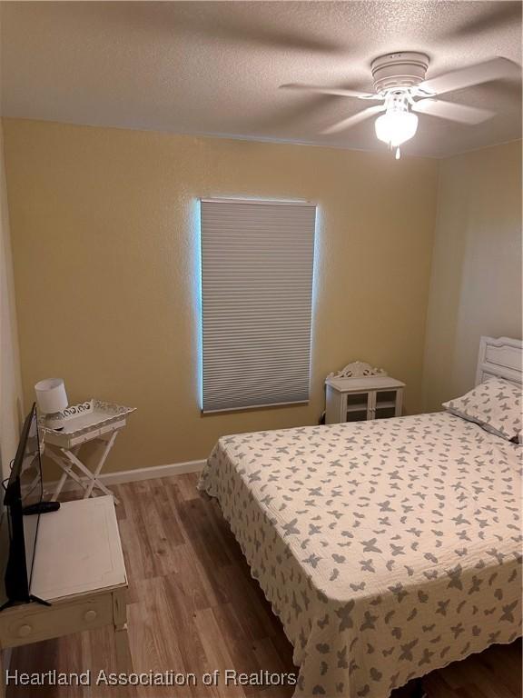 2633 W Newton Rd, Avon Park, FL 33825 - bedroom with a textured ceiling, a ceiling fan, and wood finished floors