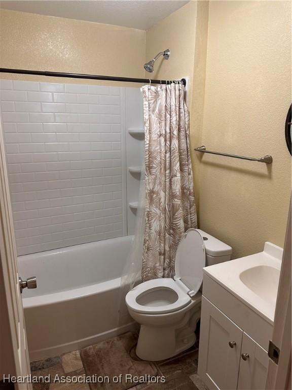 full bathroom with toilet, vanity, and shower / tub combo with curtain