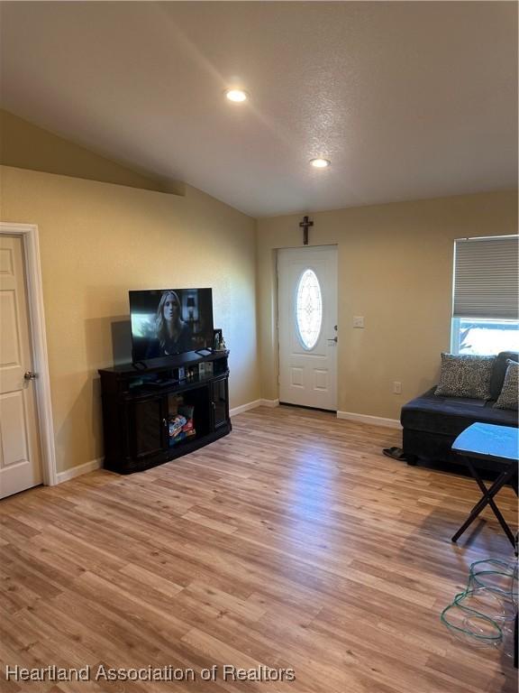 foyer with plenty of natural light, light hardwood / wood-style flooring, and vaulted ceiling