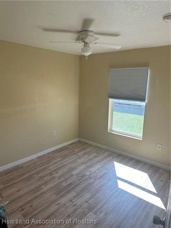 2633 W Newton Rd, Avon Park, FL 33825 - spare room with a textured ceiling, wood finished floors, ceiling fan, and baseboards