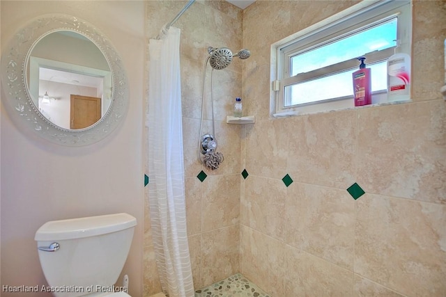 full bath with toilet and a tile shower