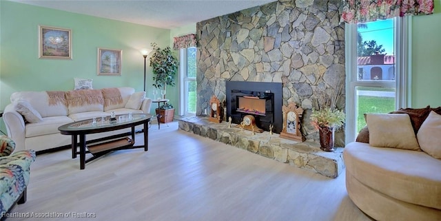 living room with wood finished floors, a fireplace, and a wealth of natural light