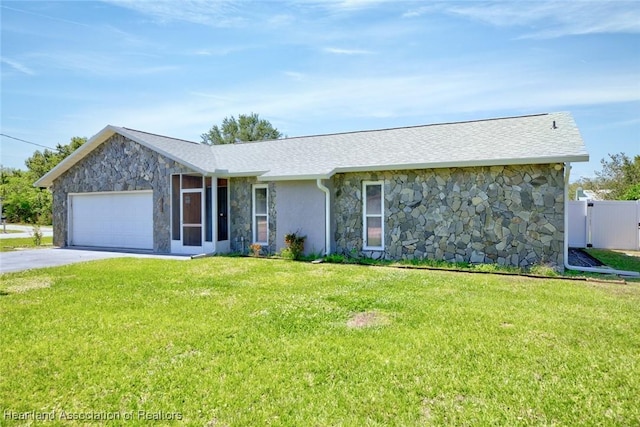 ranch-style home with stone siding, a front lawn, an attached garage, a shingled roof, and driveway