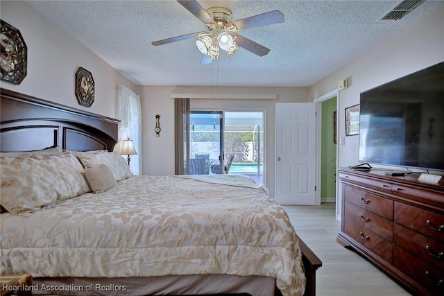 bedroom with visible vents, a ceiling fan, light wood-type flooring, a textured ceiling, and access to exterior