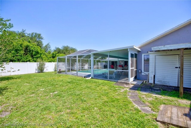 view of yard with a fenced in pool, a fenced backyard, and a lanai