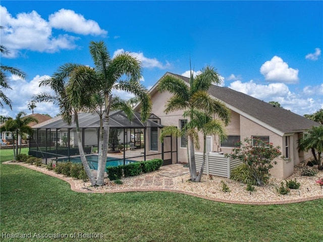 rear view of property with an outdoor pool, glass enclosure, a lawn, and stucco siding