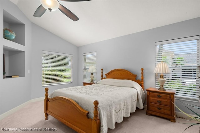 bedroom featuring light carpet, baseboards, vaulted ceiling, and a ceiling fan