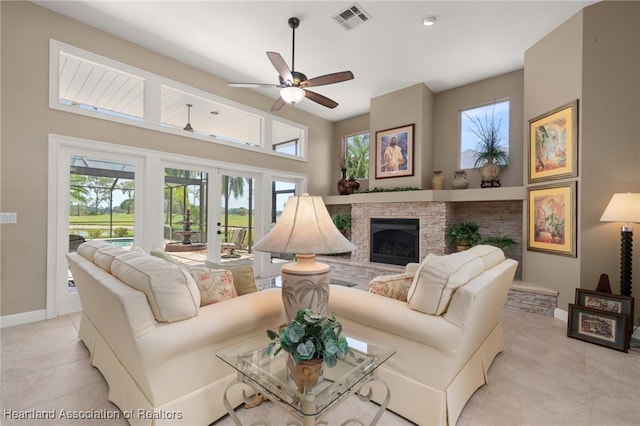 living room with light tile patterned floors, baseboards, a ceiling fan, and visible vents