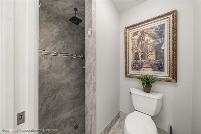 bathroom featuring tiled shower, baseboards, and toilet