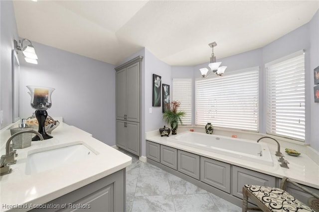full bathroom featuring a bath, marble finish floor, a sink, and a notable chandelier