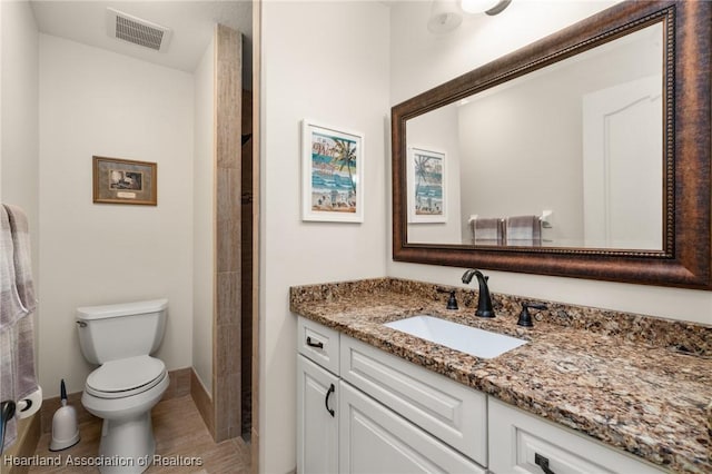 bathroom with visible vents, baseboards, walk in shower, toilet, and vanity