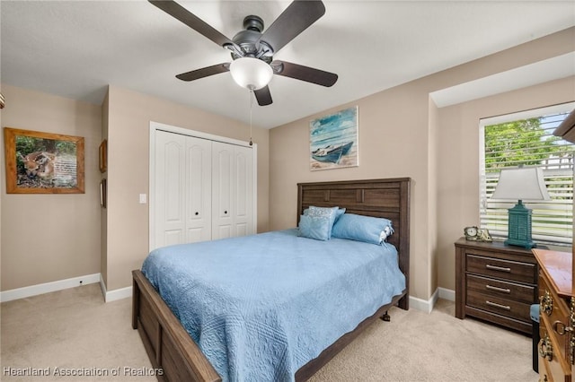 bedroom with a closet, light carpet, baseboards, and a ceiling fan