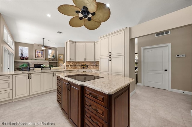 kitchen with ceiling fan, visible vents, cream cabinets, black electric stovetop, and decorative backsplash