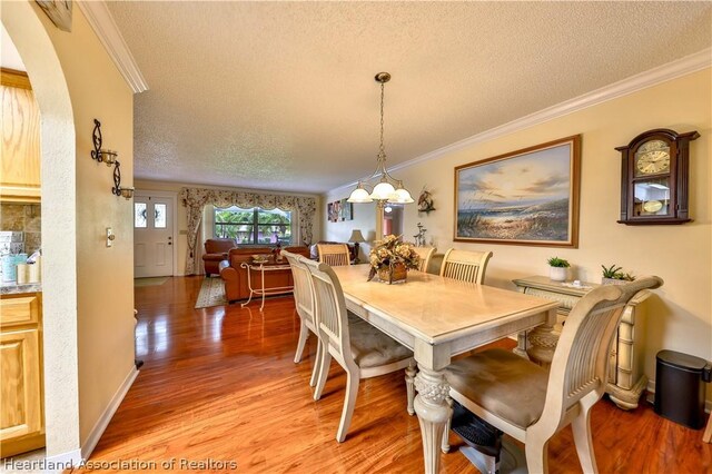 316 Fox Rd, Lake Placid, FL 33852 - dining area with hardwood / wood-style floors, crown molding, and a textured ceiling