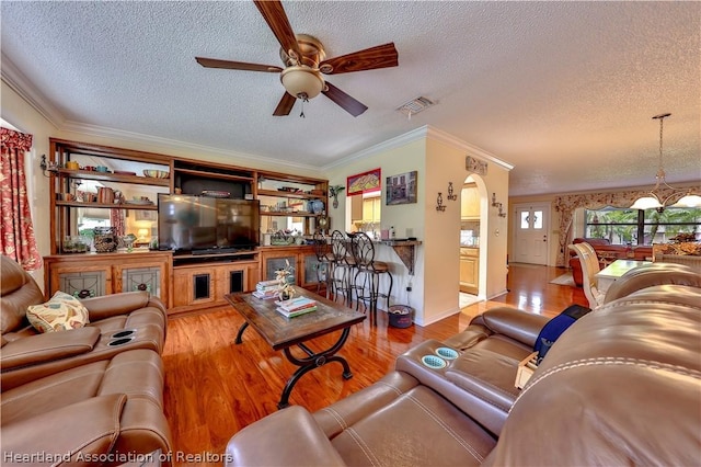 316 Fox Rd, Lake Placid, FL 33852 - living room featuring a textured ceiling, ceiling fan with notable chandelier, light hardwood / wood-style flooring, and crown molding