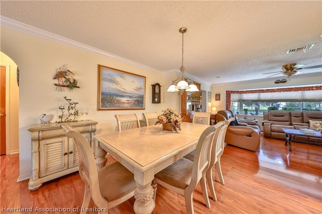 316 Fox Rd, Lake Placid, FL 33852 - dining room featuring ceiling fan with notable chandelier, a textured ceiling, hardwood / wood-style flooring, and crown molding