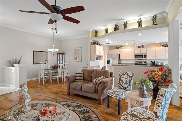 living room featuring crown molding, ceiling fan with notable chandelier, and light wood-type flooring