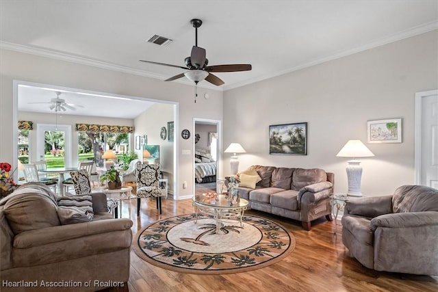 living room with hardwood / wood-style flooring, ornamental molding, and ceiling fan