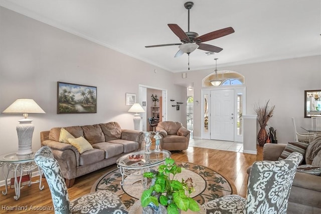 living room featuring ceiling fan, ornamental molding, and light hardwood / wood-style floors