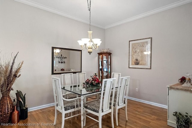 dining area featuring hardwood / wood-style flooring, ornamental molding, and a chandelier