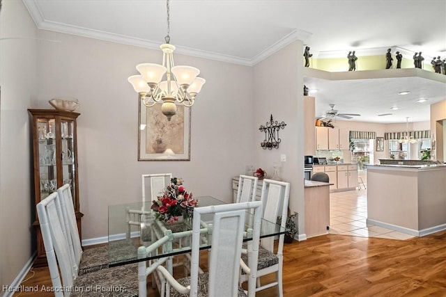 dining room with ornamental molding, ceiling fan with notable chandelier, and light hardwood / wood-style flooring