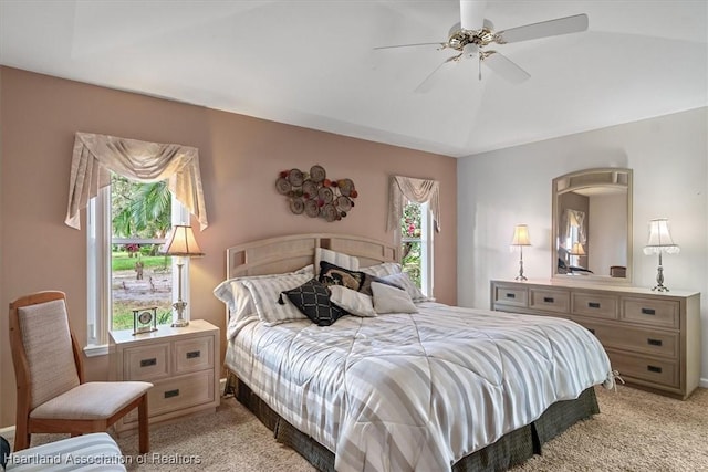 bedroom with ceiling fan, vaulted ceiling, and light carpet