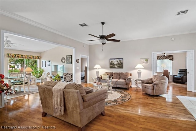 living room featuring hardwood / wood-style flooring, crown molding, and ceiling fan