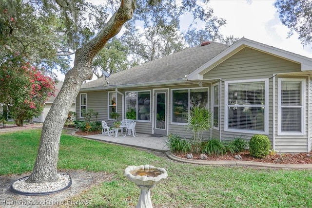 rear view of property featuring a yard and a patio area