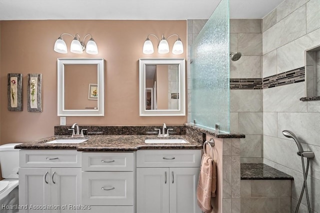 bathroom featuring tiled shower, vanity, and toilet