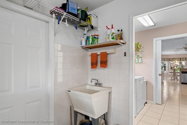 interior space featuring ceiling fan, sink, tile walls, and light tile patterned floors