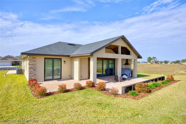 rear view of property with a patio area, central AC unit, and a lawn