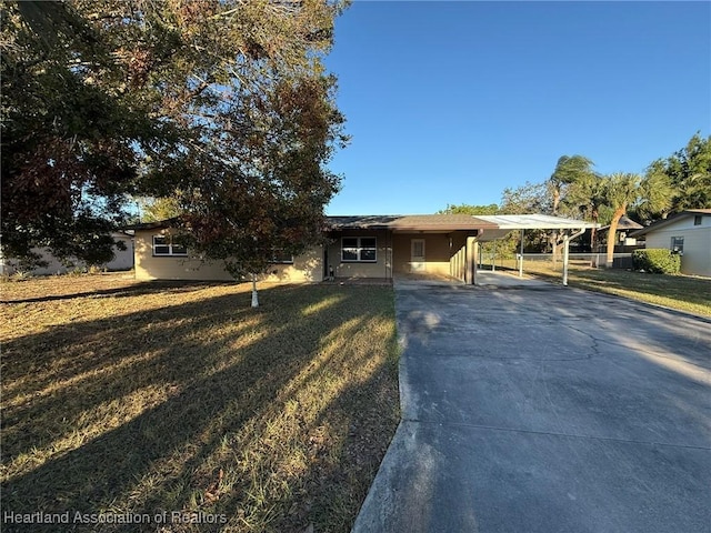 single story home featuring a carport, concrete driveway, and a front yard