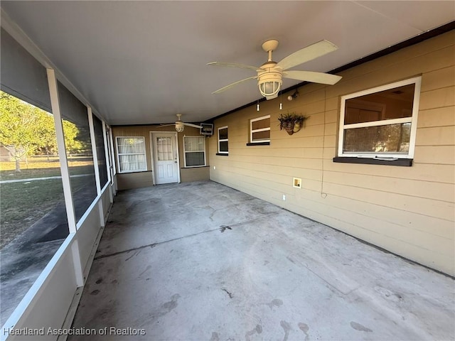 unfurnished sunroom featuring ceiling fan