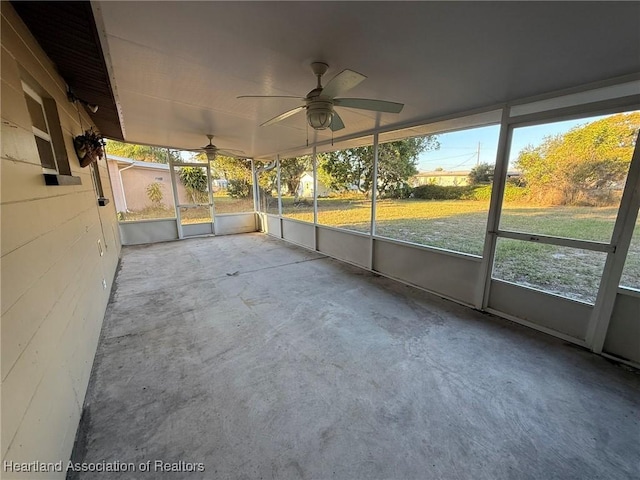 unfurnished sunroom featuring ceiling fan