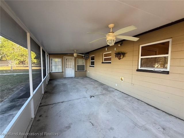 unfurnished sunroom featuring ceiling fan