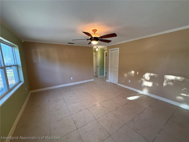 spare room with light tile patterned floors, a textured ceiling, ceiling fan, and ornamental molding