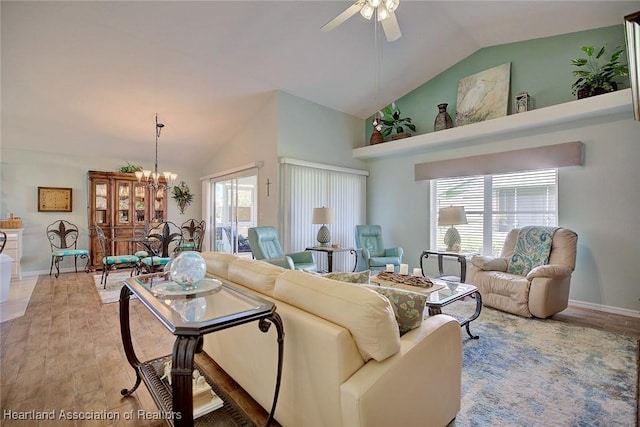 living room featuring hardwood / wood-style floors, ceiling fan with notable chandelier, high vaulted ceiling, and plenty of natural light