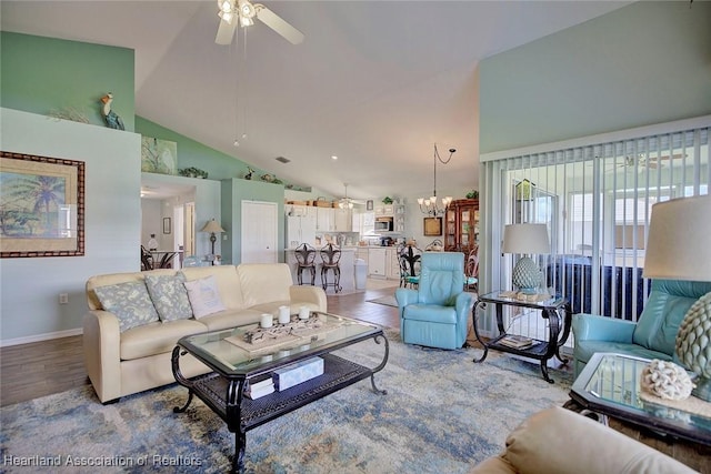 living room featuring high vaulted ceiling and ceiling fan with notable chandelier